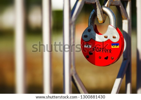 Red old style rare lock on a bridge with Poland and Ukraine labels on it symbolized forever love and friendship