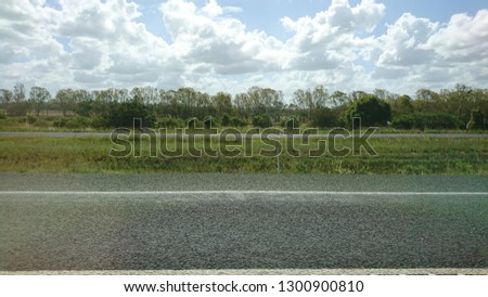 Verdant rural landscape under a dramatic cloudscape and blue sky in tropical Northern Queensland