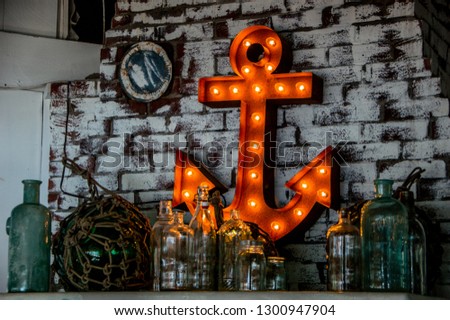 Light up anchor on a white brick wall. Picture contains nautical decorations at a restaurant in Maine. Great background photo for a website