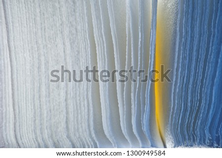 Background of porous paper, illuminated with blue and yellow LED lamps. Texture and abstraction