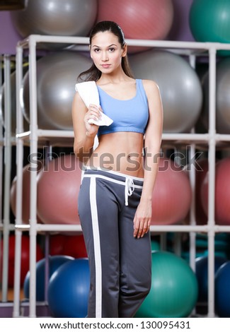 Portrait of sporting young woman in sportswear holding a towel in gym after gymnastics. Healthy lifestyle