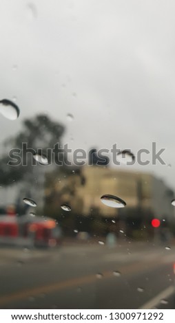 raindrops on auto glass overlooking the car and the city