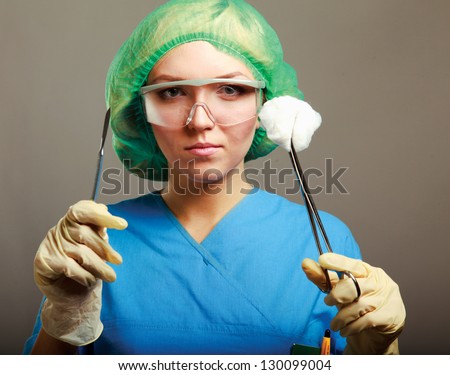 Portrait of young woman doctor surgeon (or nurse) with scalpel.