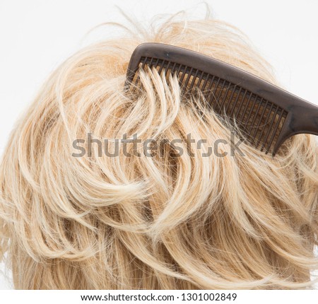 Artificial Fake Hair Wig on Rattan Head Mannequin wooden stand, studio lighting isolated on white gray close up detail of hair copy space text logo, color blonde curl straight top, professional Comb