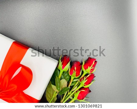 Red rose and gift box with red ribbon on black background.concept for valentine.