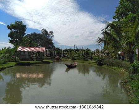 Pond with green tree and blue sky background