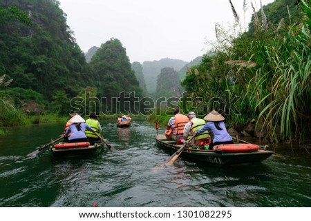 Beautiful landscape with rocks and rice fields in Ninh Binh and Tam Coc in Vietnam. Tourist in boats at the famous river.