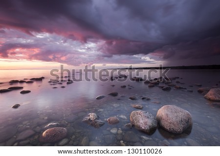 Ocean sunrise scene from the southern of Sweden, large rocks in forground