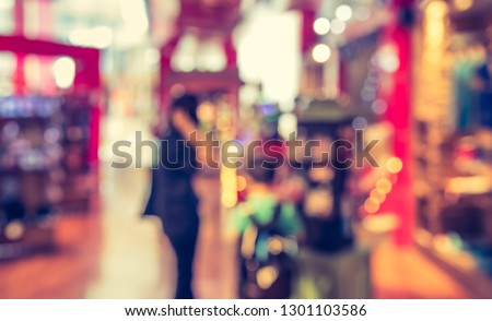 Vintage tone abstract blur image of People walking at Shopping mall with bokeh for background usage .