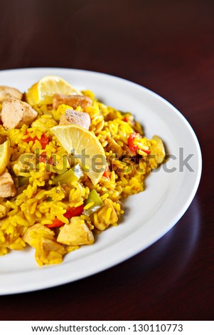 A picture of a fresh home made paella served on a white plate