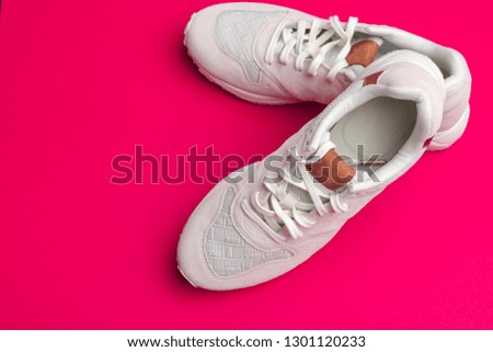 Pair of sneakers on red background, flat lay