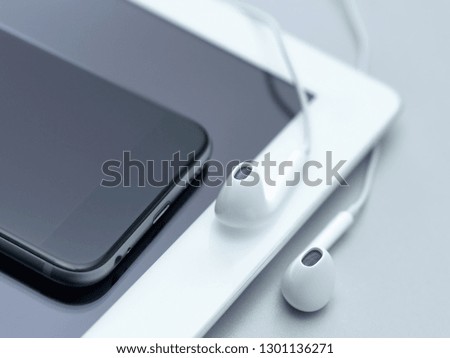 Closeup tablet and smartphone on office desk with headphones. Online music concept.
