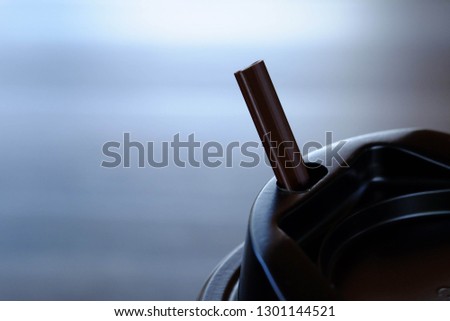 Close up of the deep brown straw for hot coffee and black coffee mug.