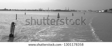 Panoramic view of Venice and its canals, from the water on a cloudy day. Black and white photography.