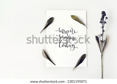 "Inspire someone today", motivational and inspirational quote. Minimal creative flat lay with flower and leaf.