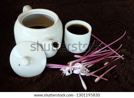 White ceramic teacup and flowers on brown background