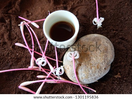 White ceramic teacup and flowers on brown background