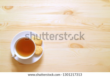Top View of a Cup of Hot tea and Cookies on Natural Wooden Table with Free Space for Text and Design