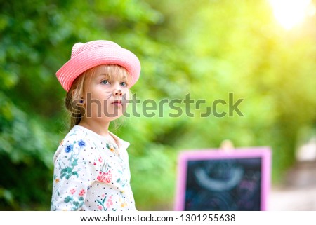 Portrait of a pensive child against an easel in the woods