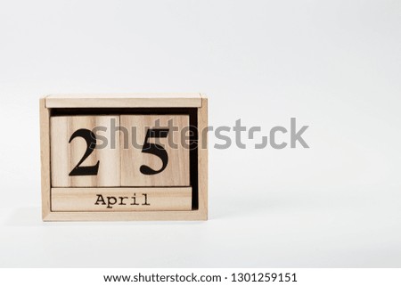 Wooden calendar April 25 on a white background close up