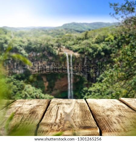 Wooden table of free space and waterfall . Summer background space. 