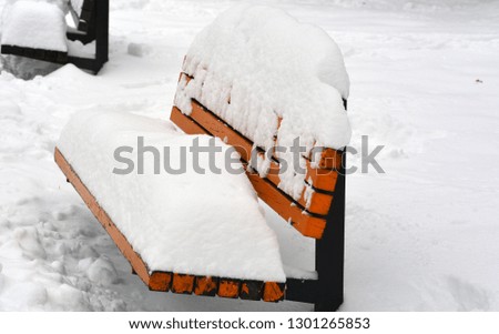 the public park bench covered by snow