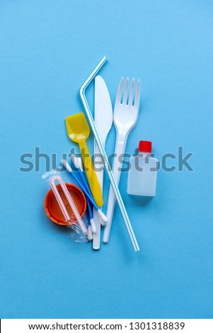 White single-use plastic and plastic drink straws on a blue background. Say no to single use plastic. Environmental, pollution concept. Royalty-Free Stock Photo #1301318839
