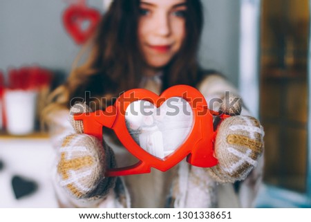 The girl holds in her hands the word love from the tree. Red wooden picture frame close up