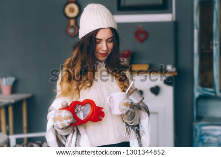 Red photoframe love and a mug in female hands close-up