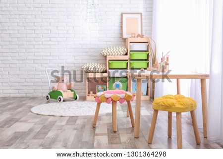 Modern eco style interior of child room with wooden crates near brick wall