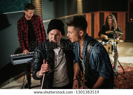 Music band having rehearsal in a studio