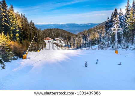 Bansko, Bulgaria ski resort panoramic view with mountain peaks, pine trees, ski slope, restaurants and ski lifts Royalty-Free Stock Photo #1301439886