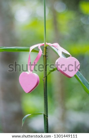 Two hearts symbol of love with a background of green nature