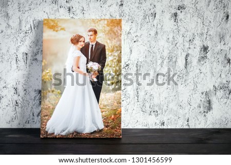 Photo of a wedding couple printed on canvas. Photography with stretch on a wooden frame on a white wall background with copy space