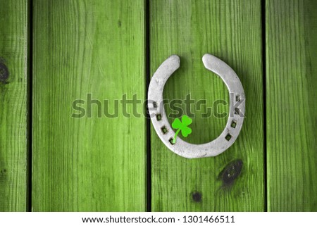 st patrick's day concept - horseshoe with shamrock on green wood boards