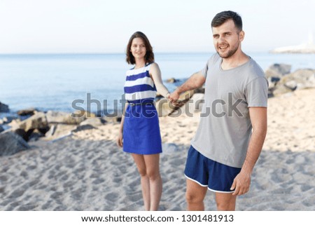 Young loving couple walking on the beach 