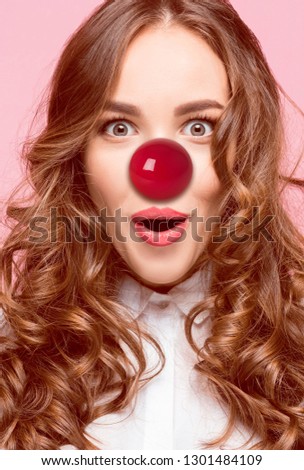 The happy surprised and smiling woman on red nose day. The clown, fun, party, celebration, funny, joy, holiday, comic, emotion, fool and humor concept