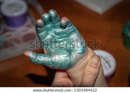 Green Paint on children's hands.