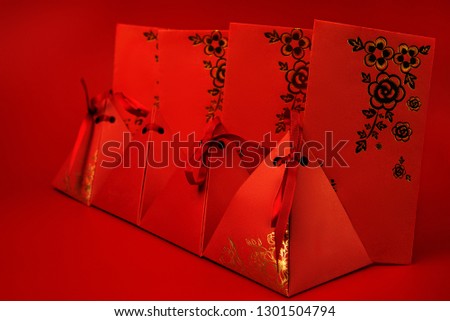 On a red background are red envelopes and red boxes with gold hieroglyphs . Chinese new year .