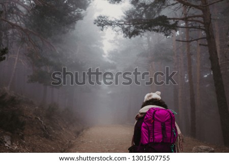 successful hiker woman walking on the fog.