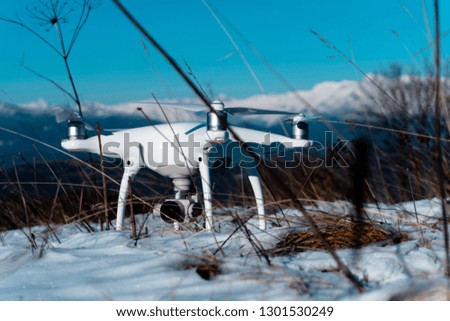 drone in snow/mountains in background