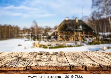 Winter landscape with an old castle and a wooden table with a free place for an advertising product among rocks