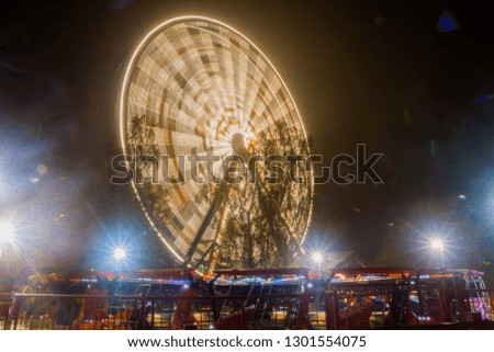 Ferris wheel in motion at the amusement park, night illumination. Long exposure.