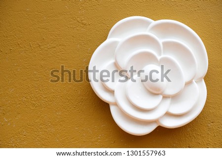 Beautiful ceramics white roses on yellow walls, pottery that separates roses shape.
