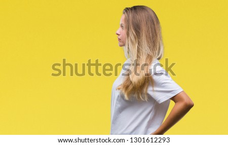 Young beautiful blonde woman wearing casual white t-shirt over isolated background looking to side, relax profile pose with natural face with confident smile.