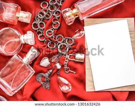 perfume bottles, jewelry and envelope on a red background. gift and congratulations