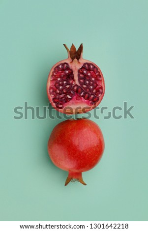 Minimalistic pomegranate isolated on a solid turquoise background