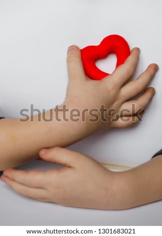 Red heart on kid hand isolated on white background