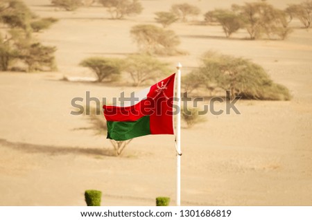 Oman national flag on a pole blown by the wind.