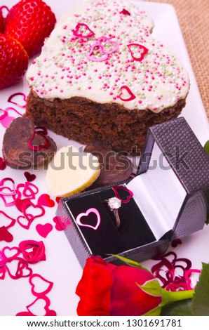 Valentine Treat.
Gold Diamond ring with a heart shaped slice of Chocolate cake, strawberries and a red rose.
